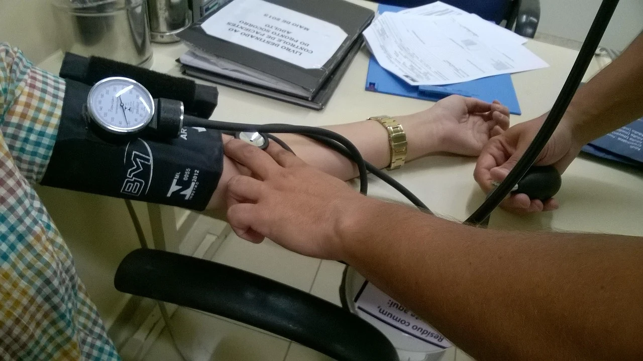 Nurse takes a patient's blood pressure with a cuff and dial gauge to check for arterial hypertension
