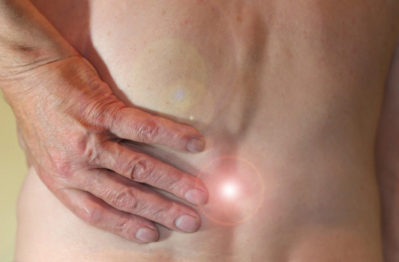 Person holds a hand on the lower back at the side where the kidneys ache, a possible sign of pyelonephritis