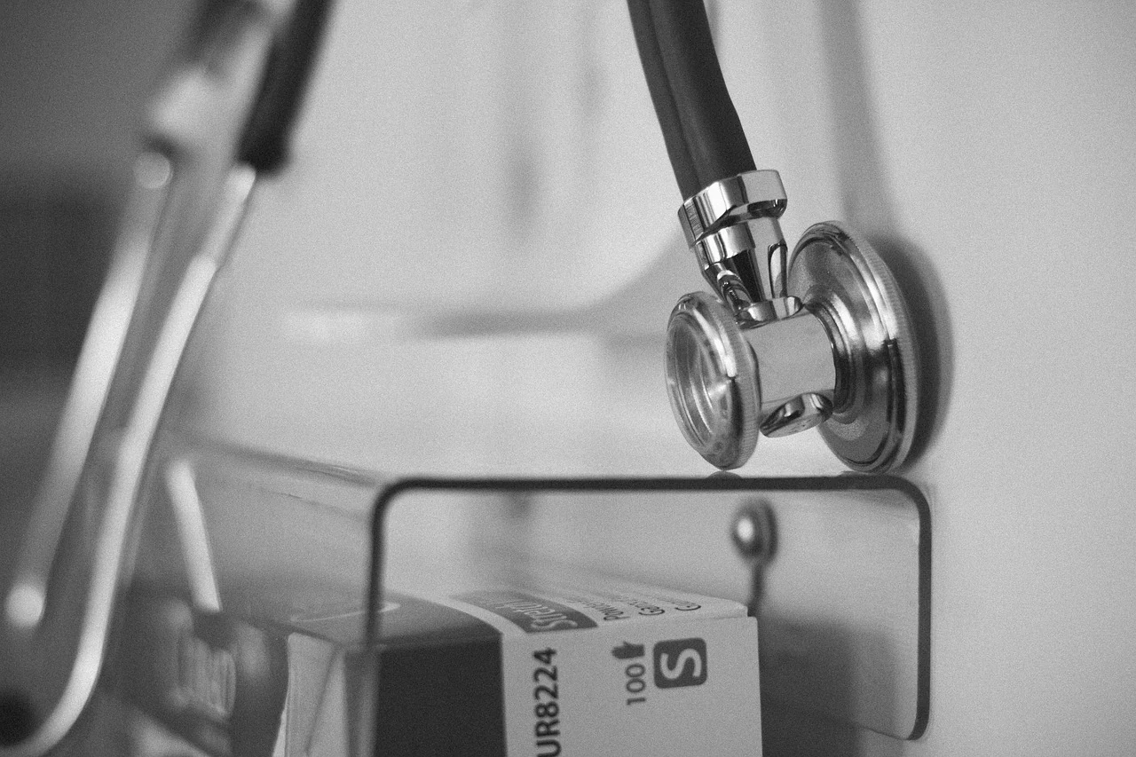 Black-and-white close-up of a metal stethoscope head, a symbol of an exam in urology and nephrology